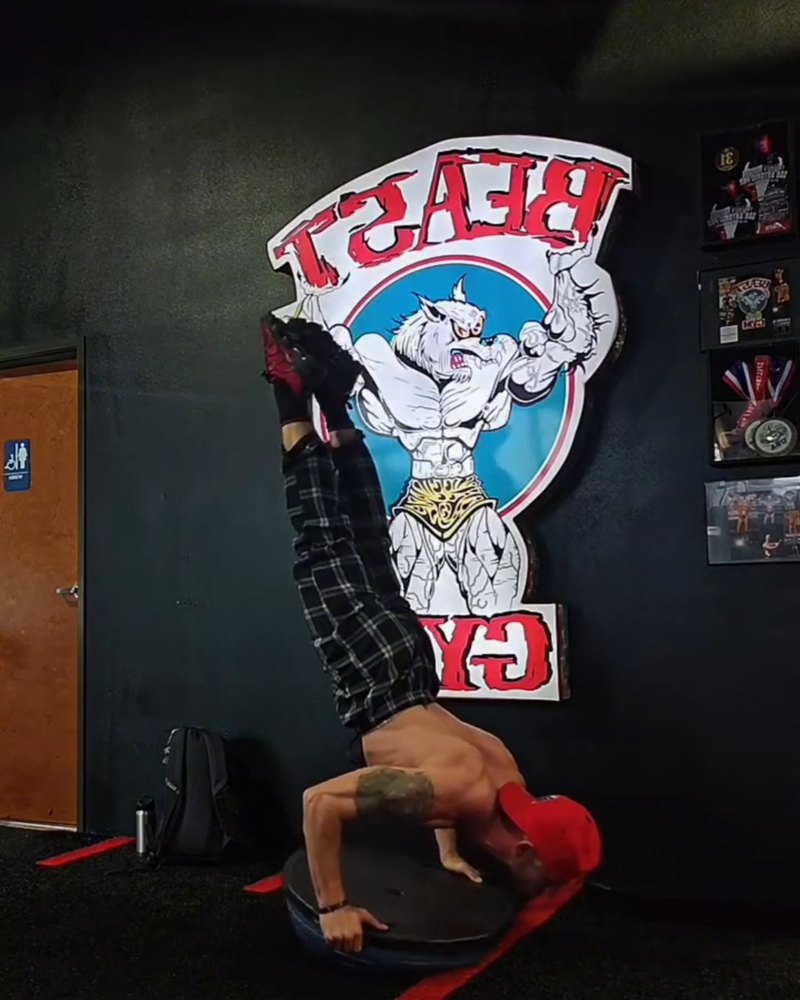 Paul doing a handstand push-up on a BOSU ball at Beast Gym