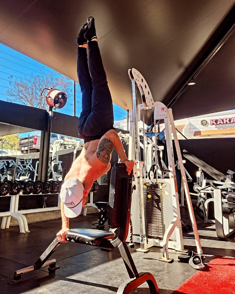 Paul holding a one-arm handstand